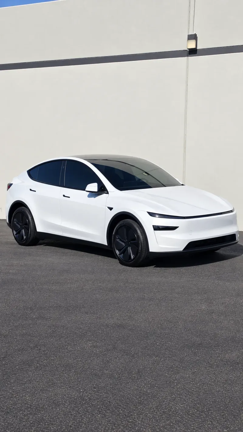 White Tesla Model Y with tinted windows outside the Avanti Window Tint shop in San Diego